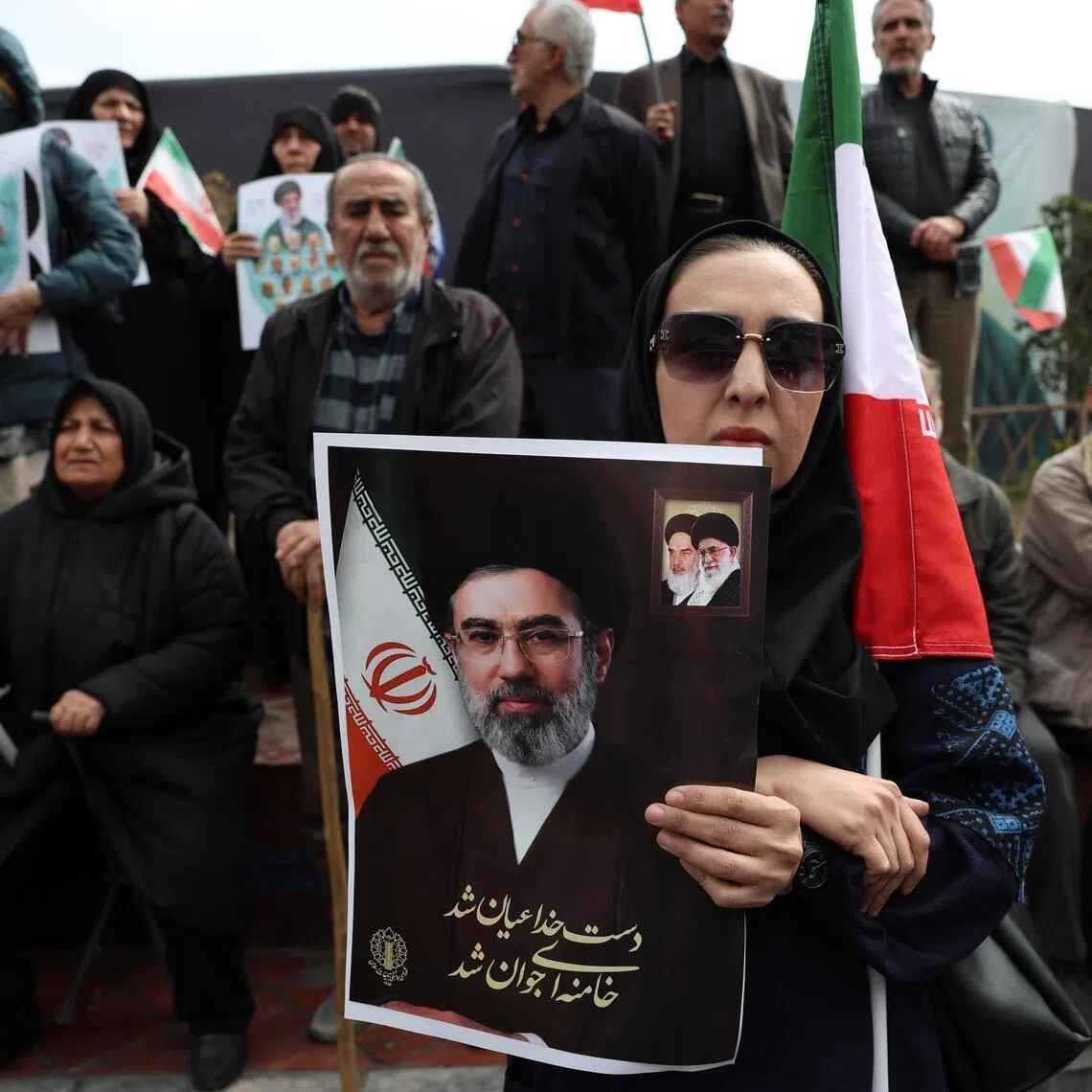 An Iranian woman holding a poster of new Iranian supreme leader Mojtaba Khamenei, who has not been seen by Iranians since his selection on March 8 by a clerical assembly.