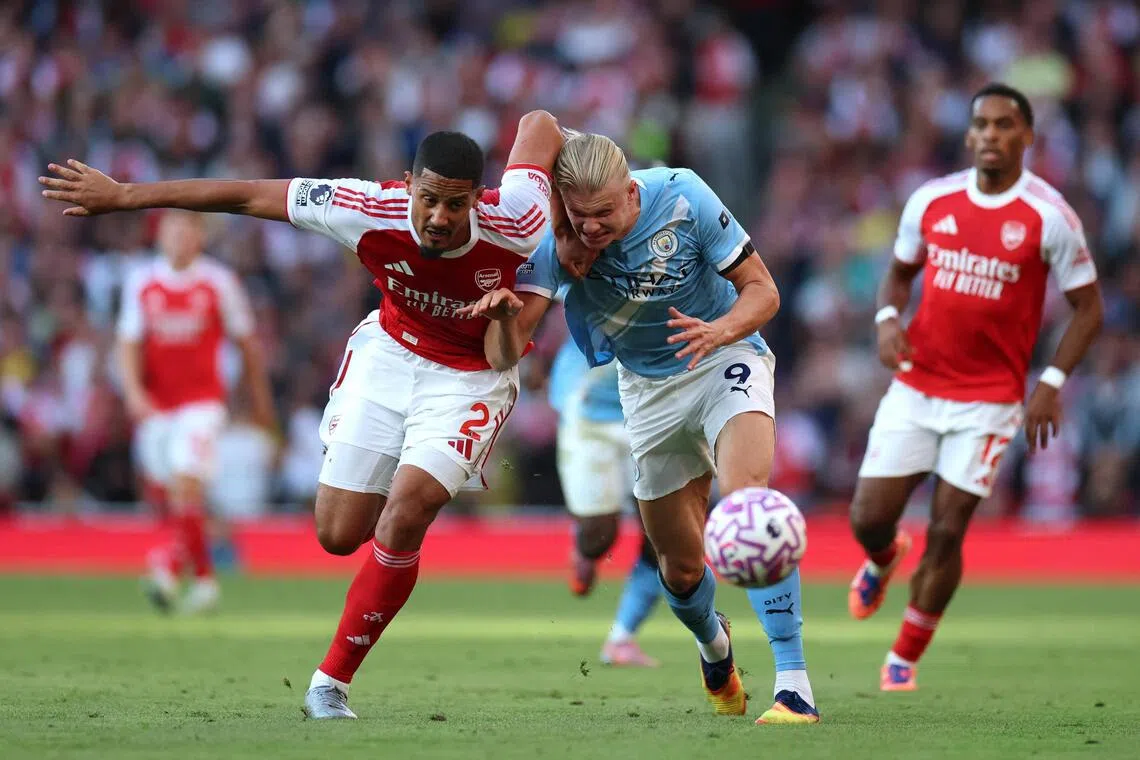 Arsenal's William Saliba taking on Manchester City's Erling Haaland during a Premier League game.