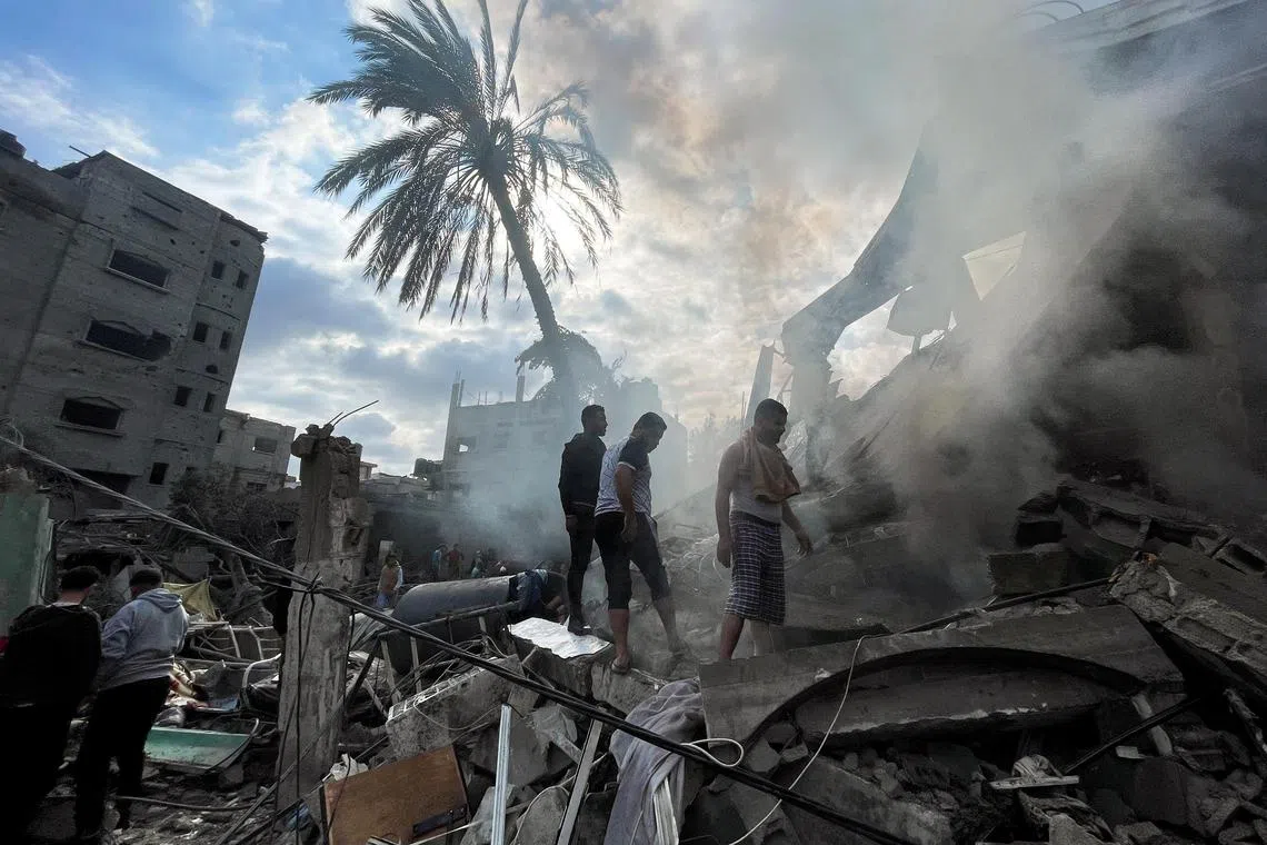 Palestinians inspect the site of an Israeli strike on a house, in Rafah in the southern Gaza Strip.