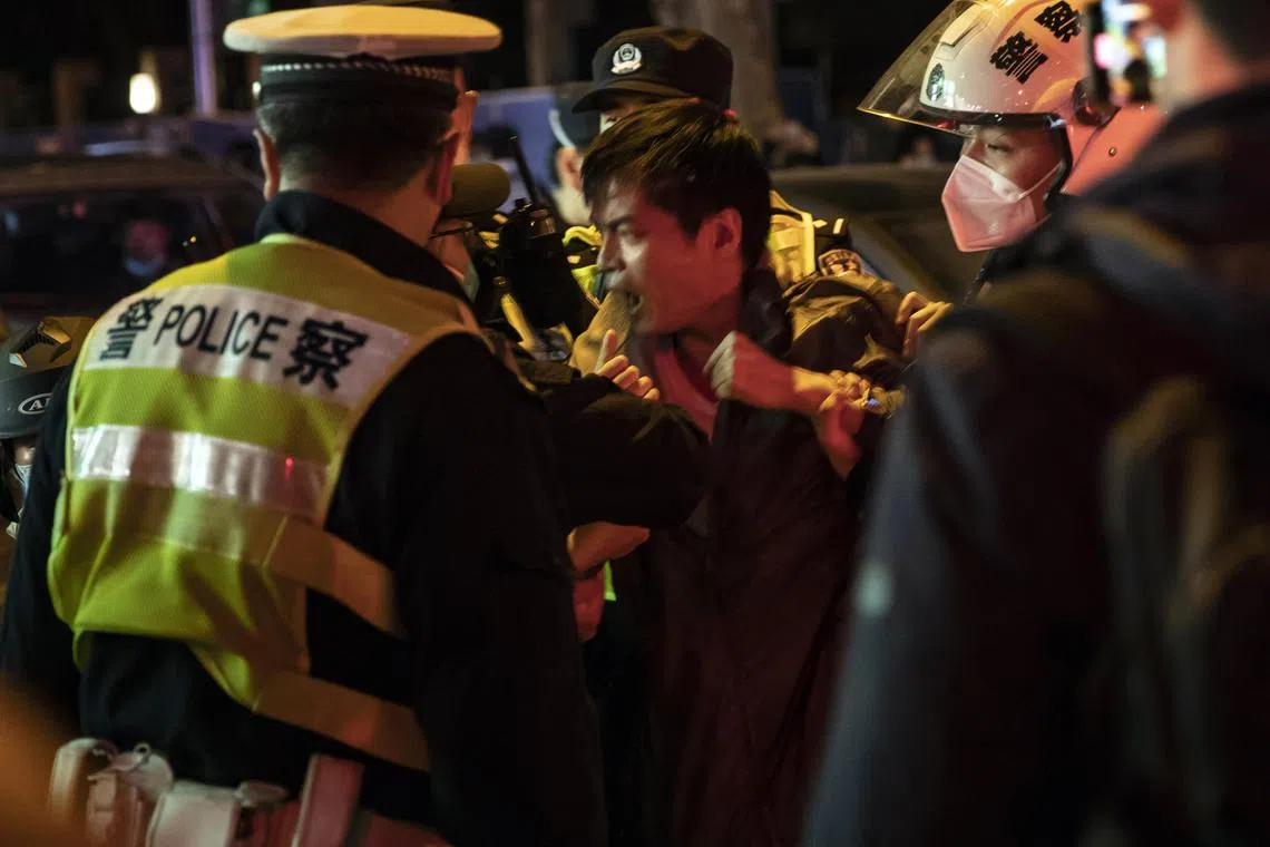 Police officers detain a man during a protest against Covid-19 rules in Shanghai, on Nov 27, 2022.