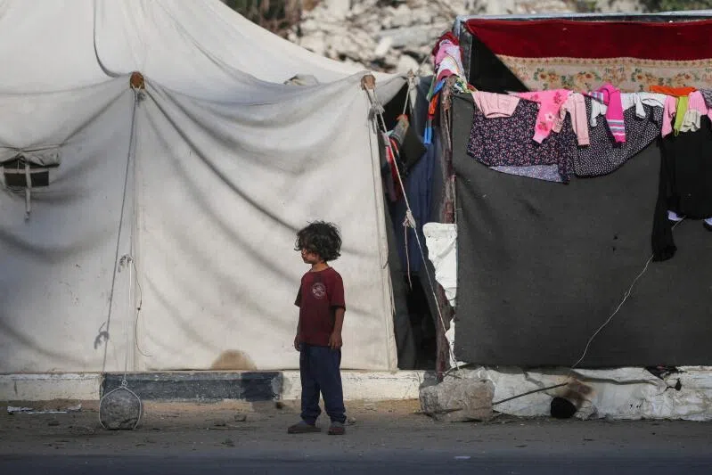 A displaced Palestinian child stands in front of tents used as temporary in the Bureij refugee camp in the central Gaza Strip on Oct 5.