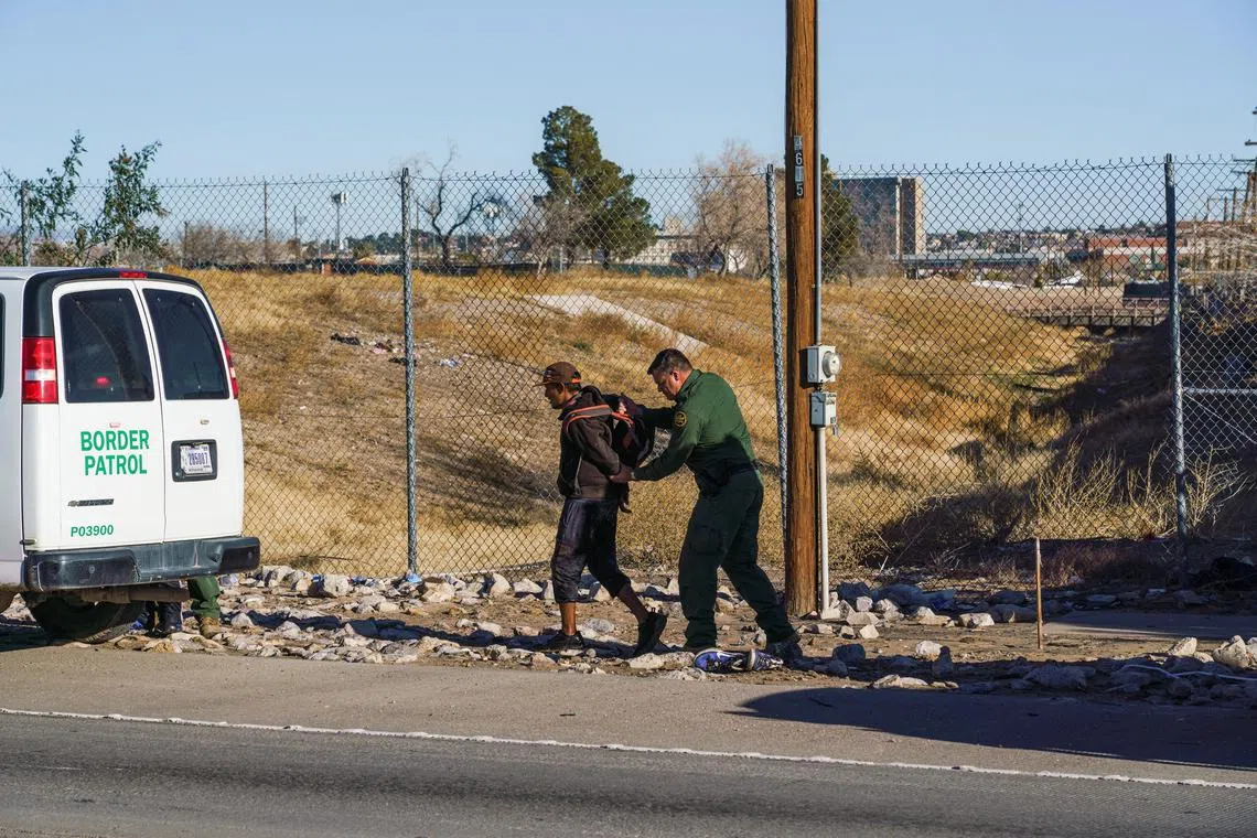 A migrant man is apprehended by a US Border Patrol agent, after  crossing the US-Mexico border, in El Paso, Texas, on Jan 4, 2022.