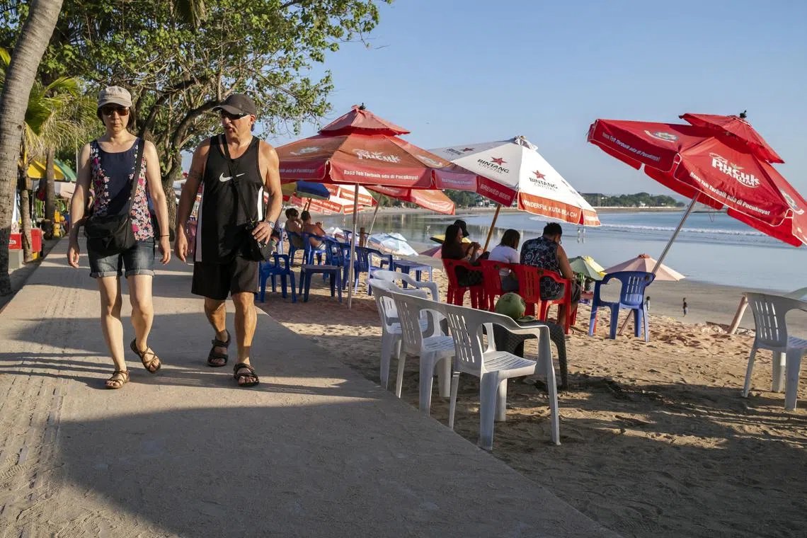 epa10645531 Foreign tourists walk at a beach in Kuta, Bali, Indonesia, 22 May 2023. The Bali Tourism Office recorded foreign tourist visits to Bali in the first quarter of 2023 reaching 1.4 million people. The Provincial Government of Bali is optimistic that the target of 4.5 million foreign tourist visits in 2023 will be achieved.  EPA-EFE/MADE NAGI