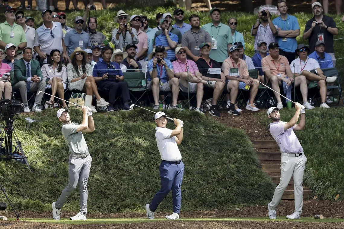 (From left) Sam Burns, Tom Kim and Scottie Scheffler tee off in tandem on the ninth hole, during the annual Par 3 Contest at the Masters Tournament, in Augusta, Georgia.