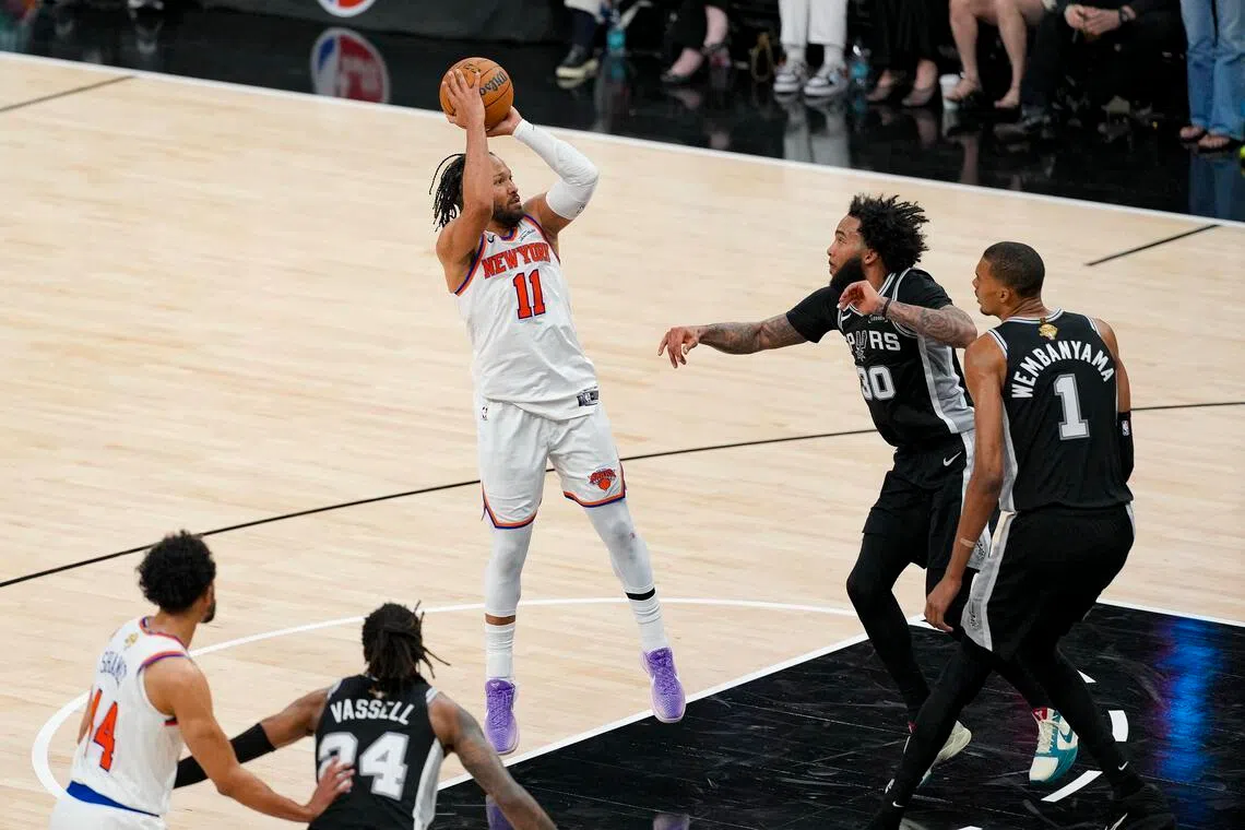 New York Knicks guard Jalen Brunson shoots the ball over San Antonio Spurs forward Julian Champagnie during the fourth quarter in Game 1 of the NBA Finals.