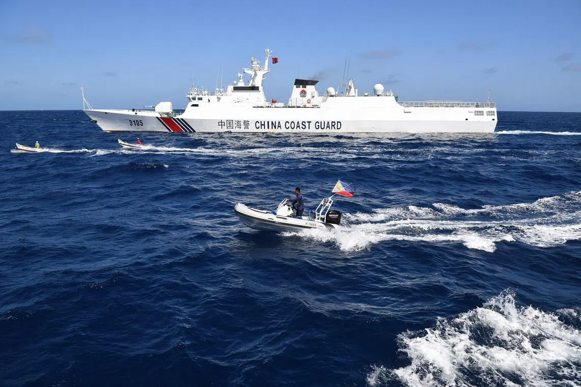 Filipino fishermen and a fisheries official sail past a Chinese coast guard ship near the disputed Scarborough Shoal.