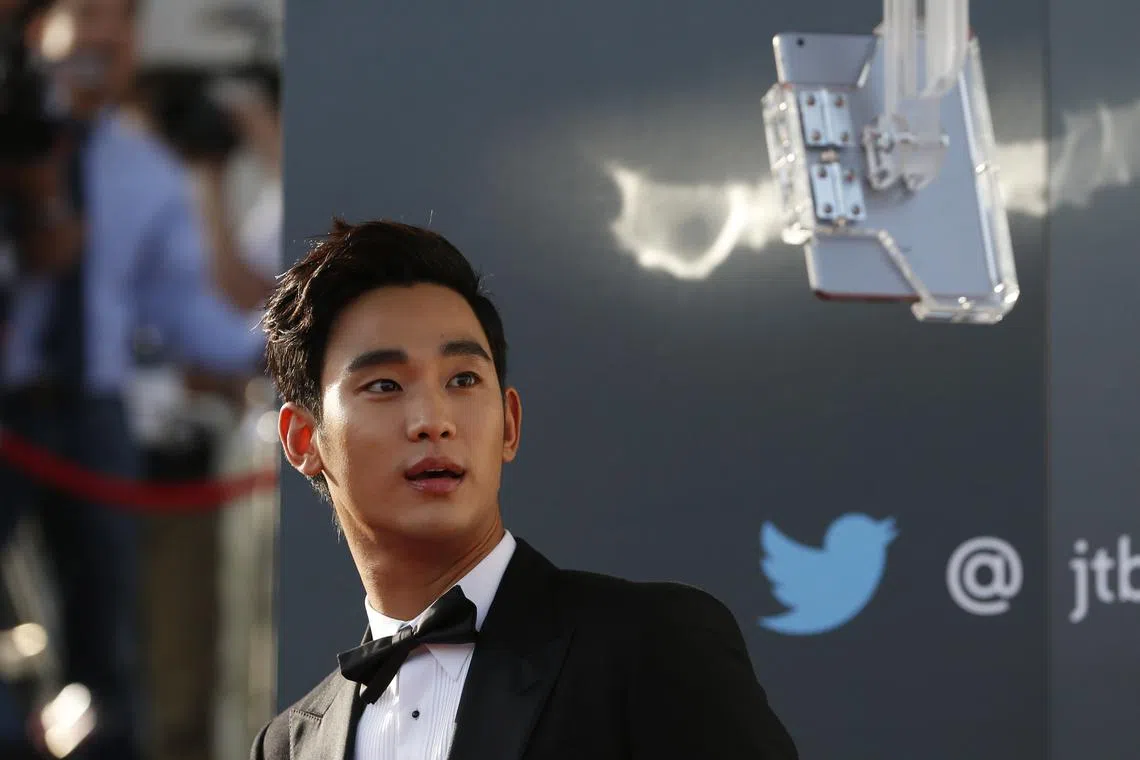 FILE PHOTO: South Korean actor Kim Soo-hyun looks at a tablet as he arrives at the 50th Baeksang Arts Awards in Seoul May 27, 2014. REUTERS/Kim Hong-Ji/File Photo
