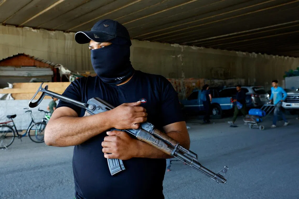 A gunman stands as Syrian security forces check vehicles entering Druze town of Jaramana, following deadly clashes sparked by a purported recording of a Druze man cursing the Prophet Mohammad which angered Sunni gunmen, as rescuers and security sources say, in southeast of Damascus, Syria April 29, 2025. REUTERS/Yamam Al Shaar
