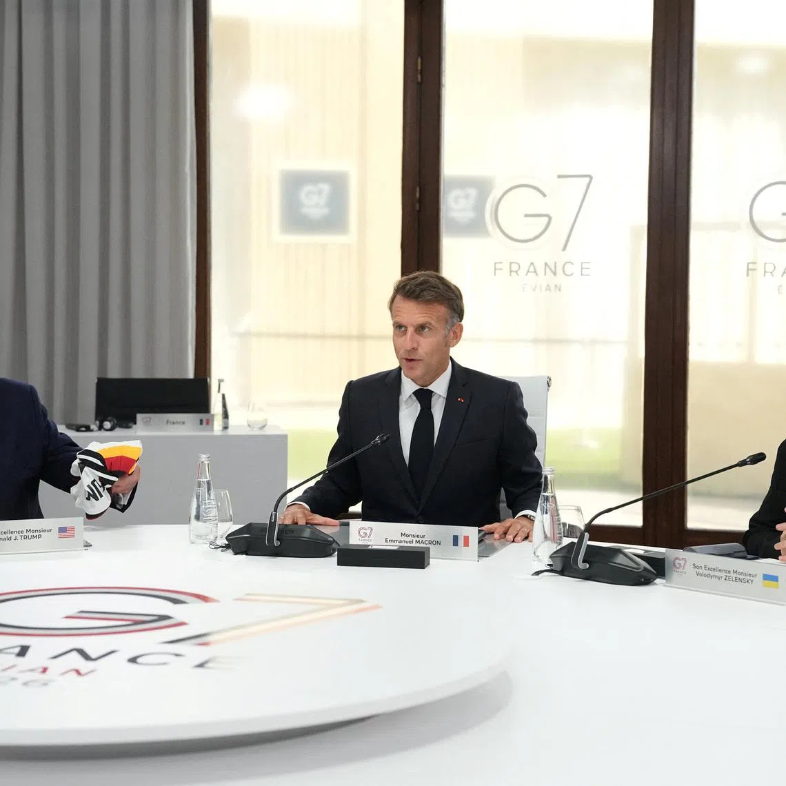 From left, U.S. President Donald Trump, French President Emmanuel Macron and Ukrainian President Volodymyr Zelenskiy during a working session at the G7 summit in Evian-les-Bains, France, June 16, 2026.     Thibault Camus/Pool via REUTERS