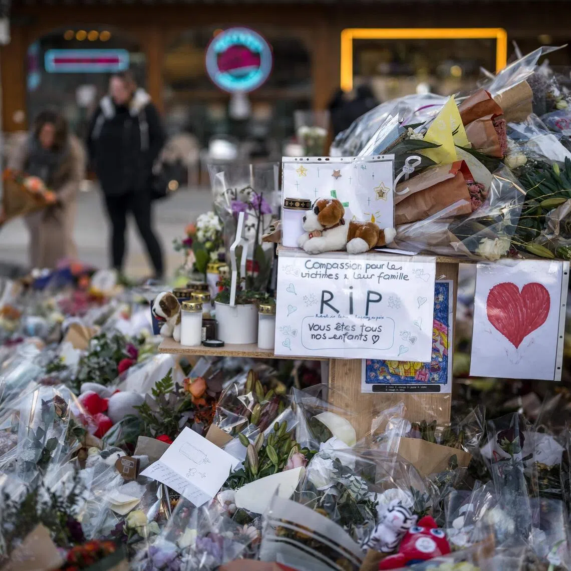 Flowers, candles and messages for the victims of the fire at a makeshift memorial near "Le Constellation" bar, in the Alpine ski resort of Crans-Montana, on Jan 6.