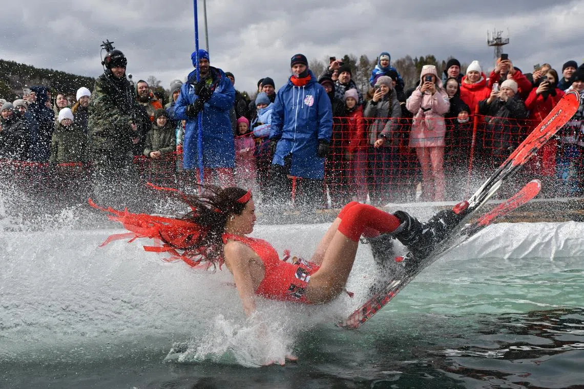 A skier in a festive costume attempting to cross a pool of water at the foot of a slope while competing in the annual Gornoluzhnik amateur event marking the end of a ski season at the Bobrovy Log fun park in Krasnoyarsk, Russia, April 19.