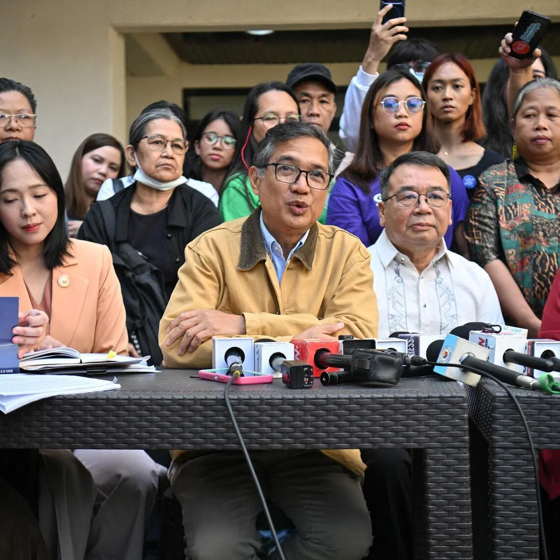 Teddy Casino (3rd L), member of progressive group Bayan, speaks during a press conference after submitting documents of an impeachment complaint against Philippine President Ferdinand Marcos to the office of the Secretary General in the House of Representatives in Quezon City, suburban Manila on January 22, 2026, alongside legislators of the progressive group Louise Co (L) and Sara Elago (2nd L). (Photo by Ted ALJIBE / AFP)