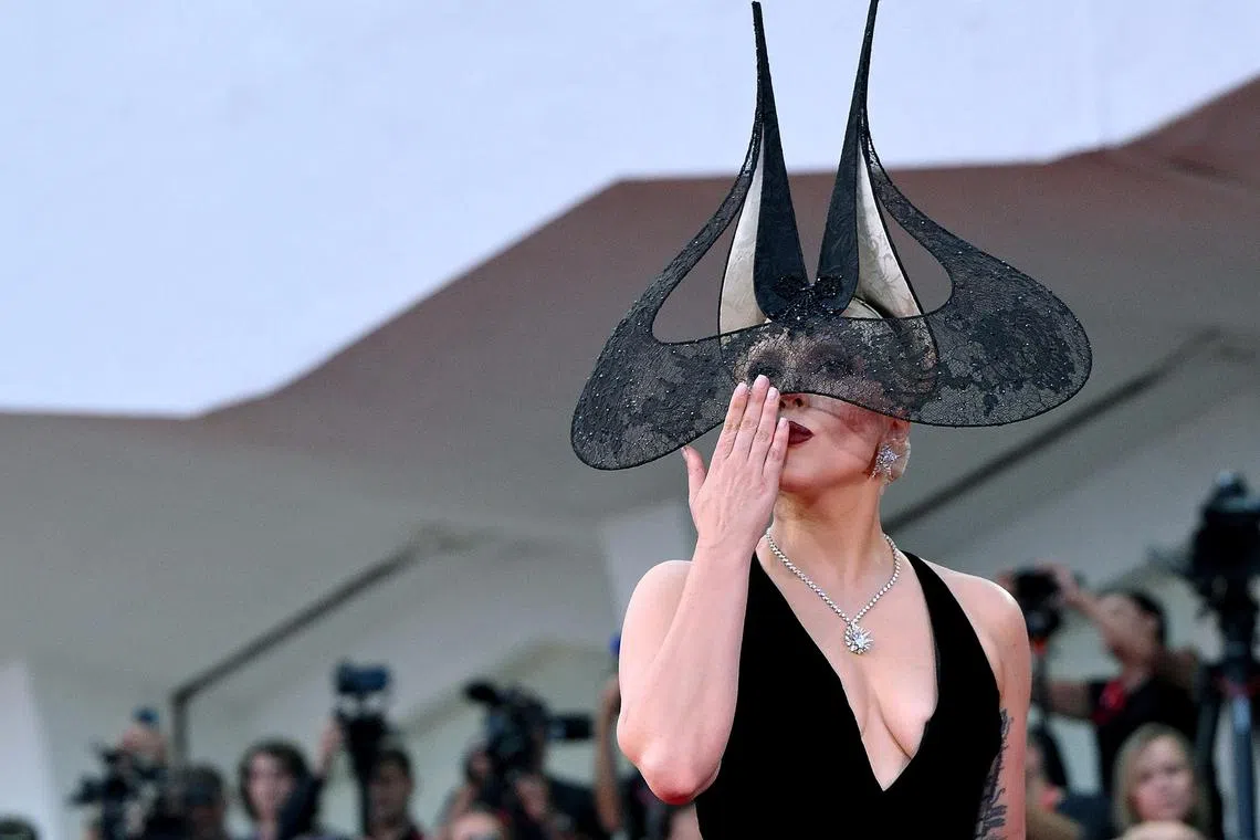 Lady Gaga drew screams from fans on the red carpet, where she showed off an elaborate mask that suggested two pointy Batman ears draped with a swathe of Venetian lace, paired with a black velvet gown with a generous taffeta skirt. 