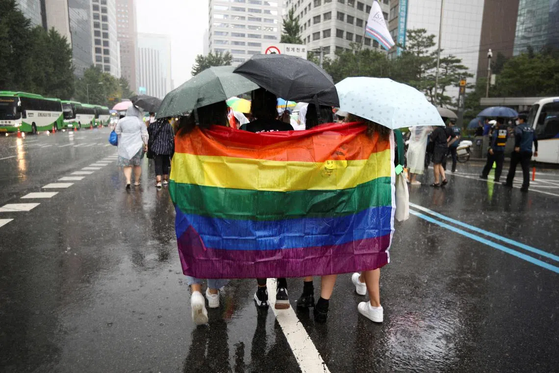Participants wave a rainbow flag as they march on a street during the Korea Queer Culture Festival 2022 in central Seoul, South Korea in July 2022. 