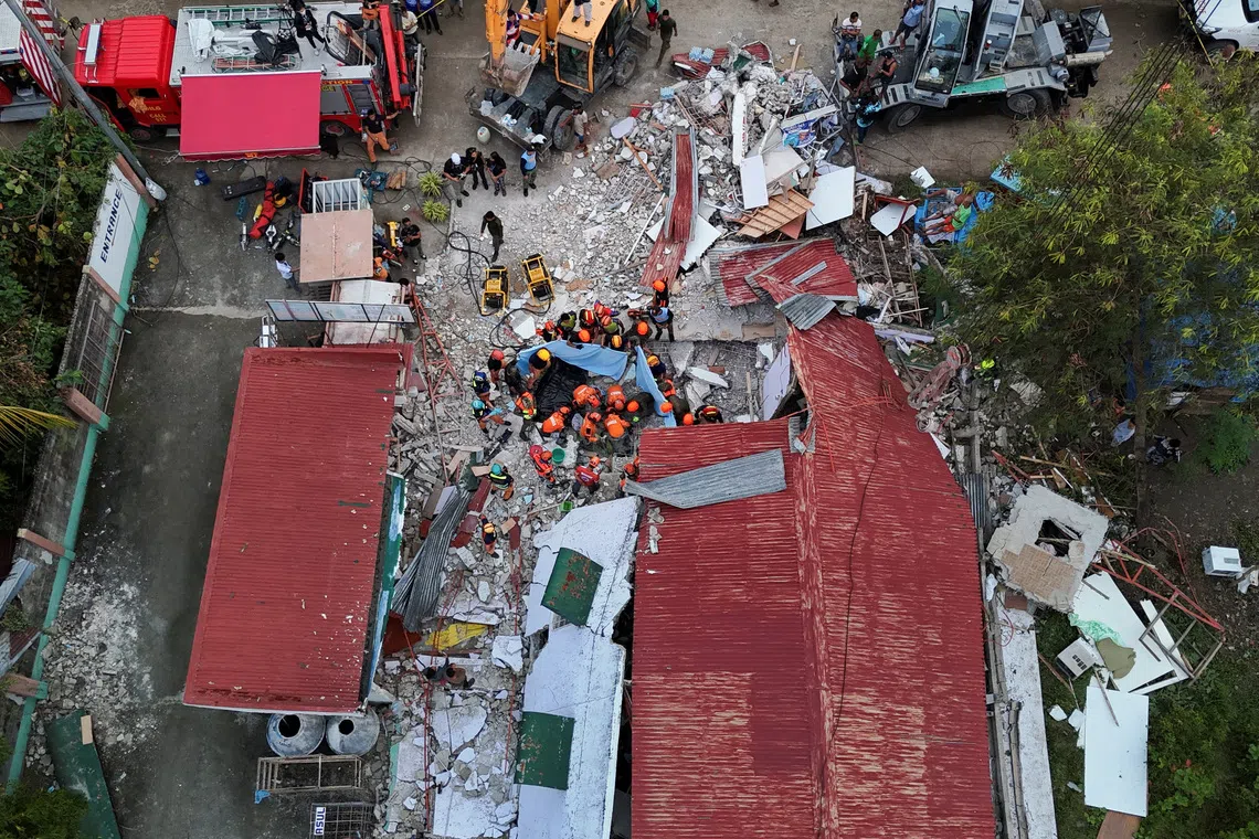 Rescue workers conducting a rescue operation at a collapsed building in the aftermath of a magnitude 6.9 quake in Bogo, Cebu, Philippines, on Oct 1.