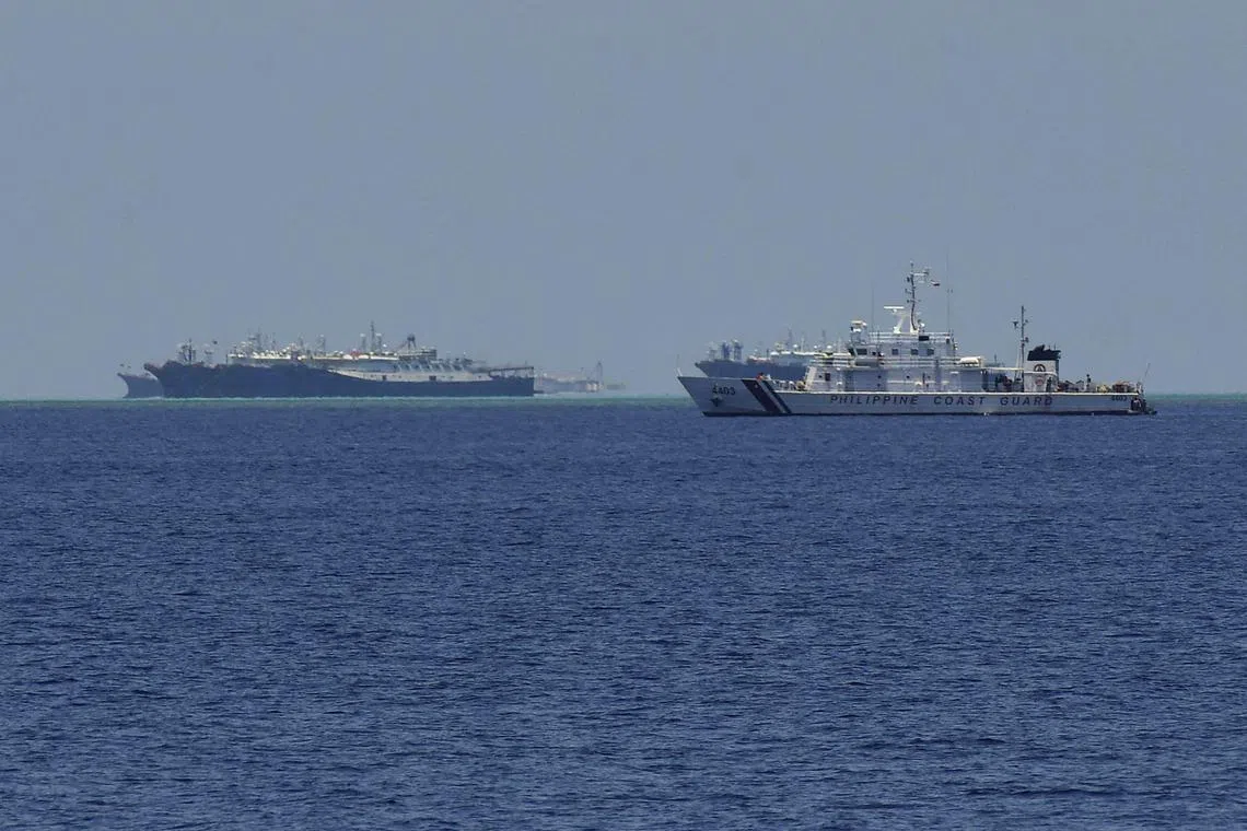 Philippine coast guard vessel (right) patrolling near Chinese vessels moored at Whitsun Reef in the Spratly Islands in the disputed South China Sea.