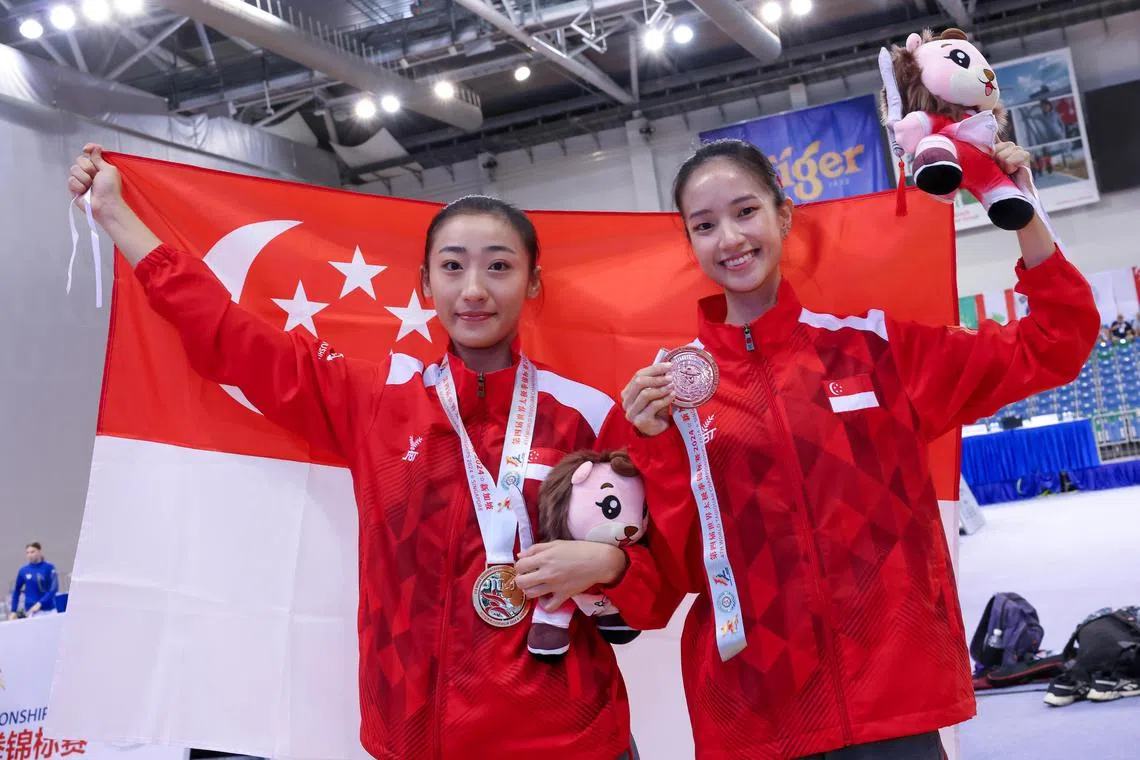 Photo :  
Singapore's Vera Tan (right) and Zeanne Law winning gold in the World Taijiquan Championships women's optional taijijian and taijiquan respectively at the OCBC Arena.