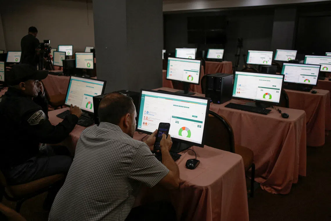 Election results are displayed on monitors in a media room at the National Electoral Council (CNE) facility as the vote count in the November 30 presidential election resumes after being suspended for three days, in Tegucigalpa, Honduras, December 8, 2025. REUTERS/Leonel Estrada