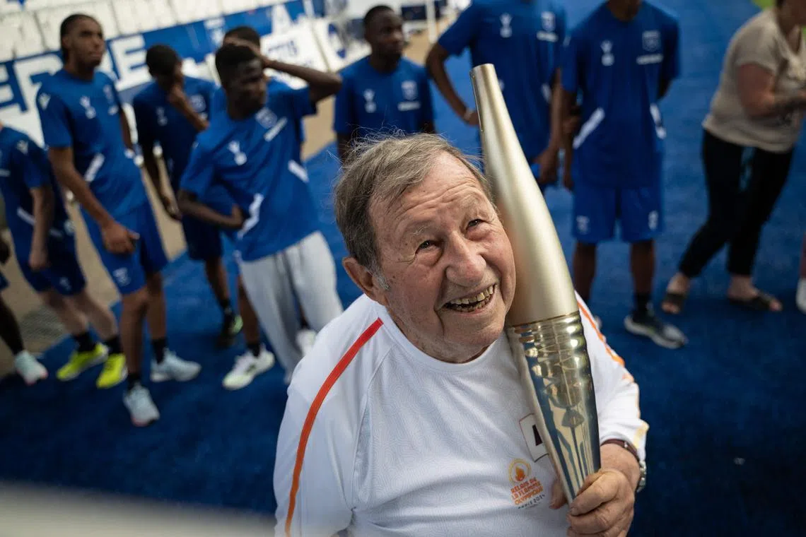 Former Ligue 1 AJ Auxerre head coach Guy Roux speaking with the public as he awaits the arrival of the Olympic flame, as part of the Olympic torch relay at the Abbe Deschamps stadium in Auxerre, central-eastern France, on July 11, 2024, ahead of the Paris 2024 Olympic Games. 