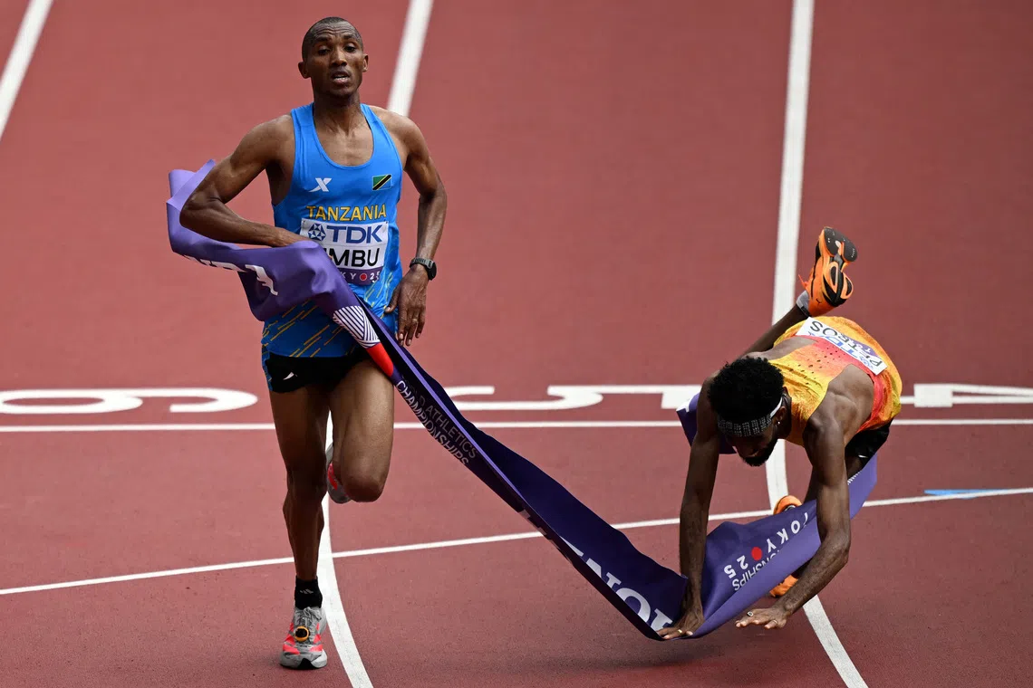 World Athletics Championships Tokyo 2025 - Men's Marathon Final - Japan National Stadium, Tokyo, Japan - September 15, 2025 Tanzania's Alphonce Felix Simbu crosses the finish line to win the men's marathon final as second placed Germany's Amanal Petros falls REUTERS/Dylan Martinez