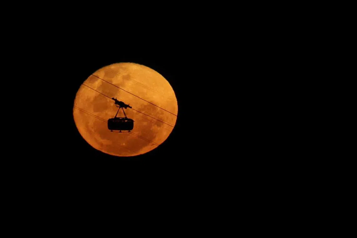 A cable car of the Pao de Acucar Mountain (Sugar Loaf Mountain) is seen passing in front of the Strawberry Moon, in Rio de Janeiro, Brazil June 4.