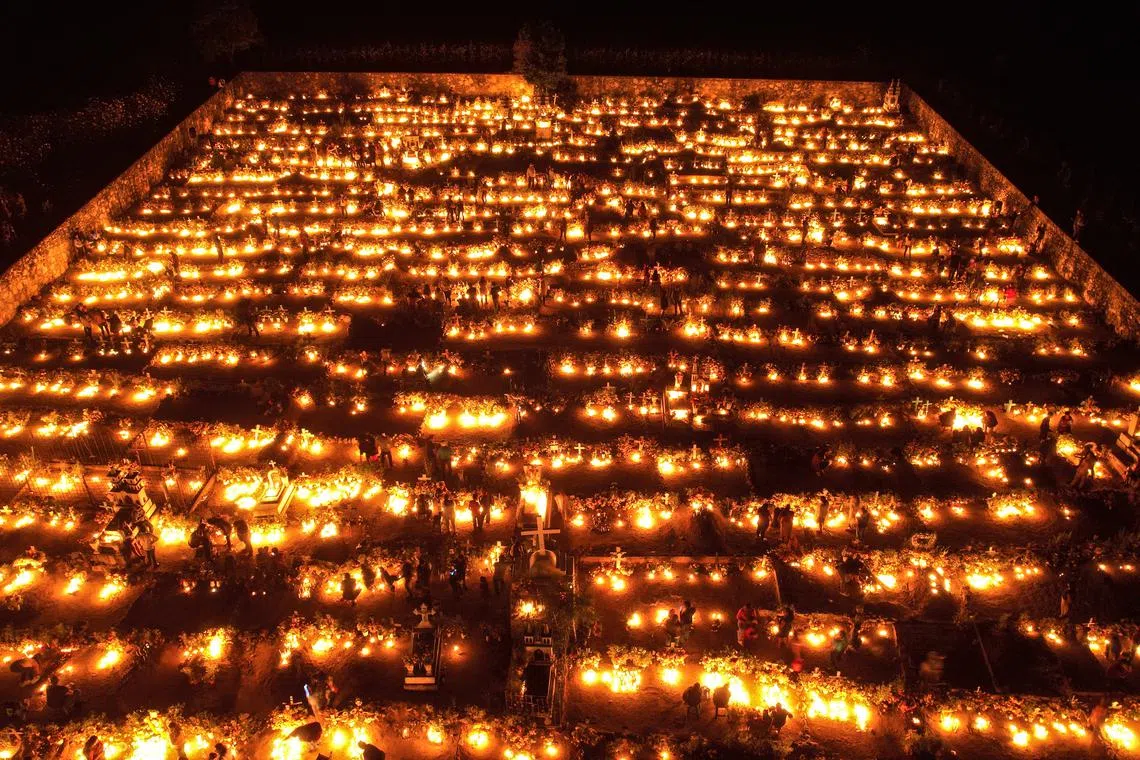  An aerial photograph shows hundreds of families as they illuminate the graves of their loved ones, in the municipal pantheon of the municipality of Huitziltepec, Guerrero state, Mexico, 01 November 2022. Mexican families once again filled cemeteries with life on the Day of the Dead, on a morning in which they mostly dedicated themselves to cleaning and preparing the cemeteries of their deceased after two years of restrictions due to the COVID-19 pandemic. 