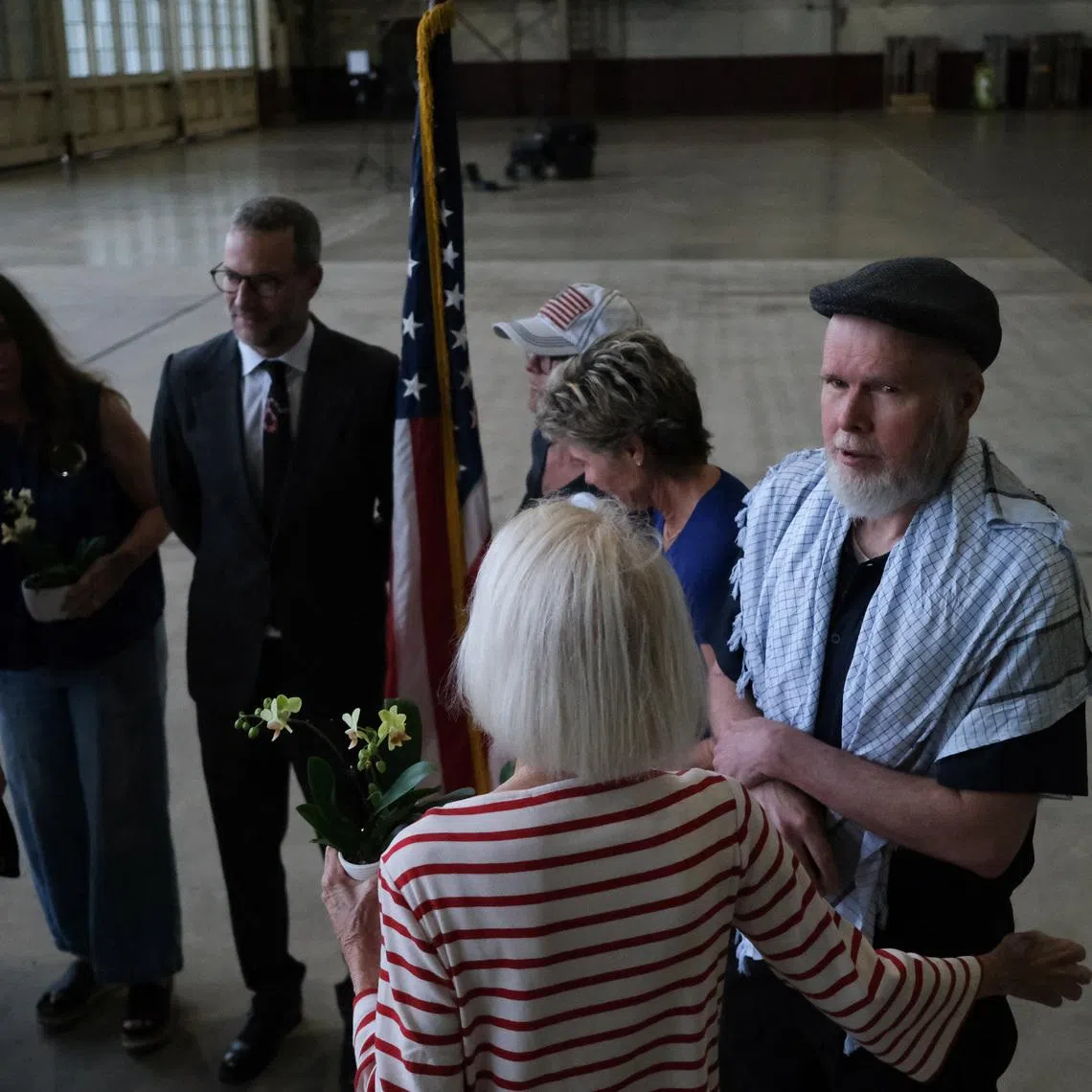 American Dennis Coyle, who was detained by the Afghan Taliban government for more than year, is greeted as he arrives at Joint Base San Antonio in San Antonio, Texas, U.S., March 25, 2026. REUTERS/Joel Angel Juarez