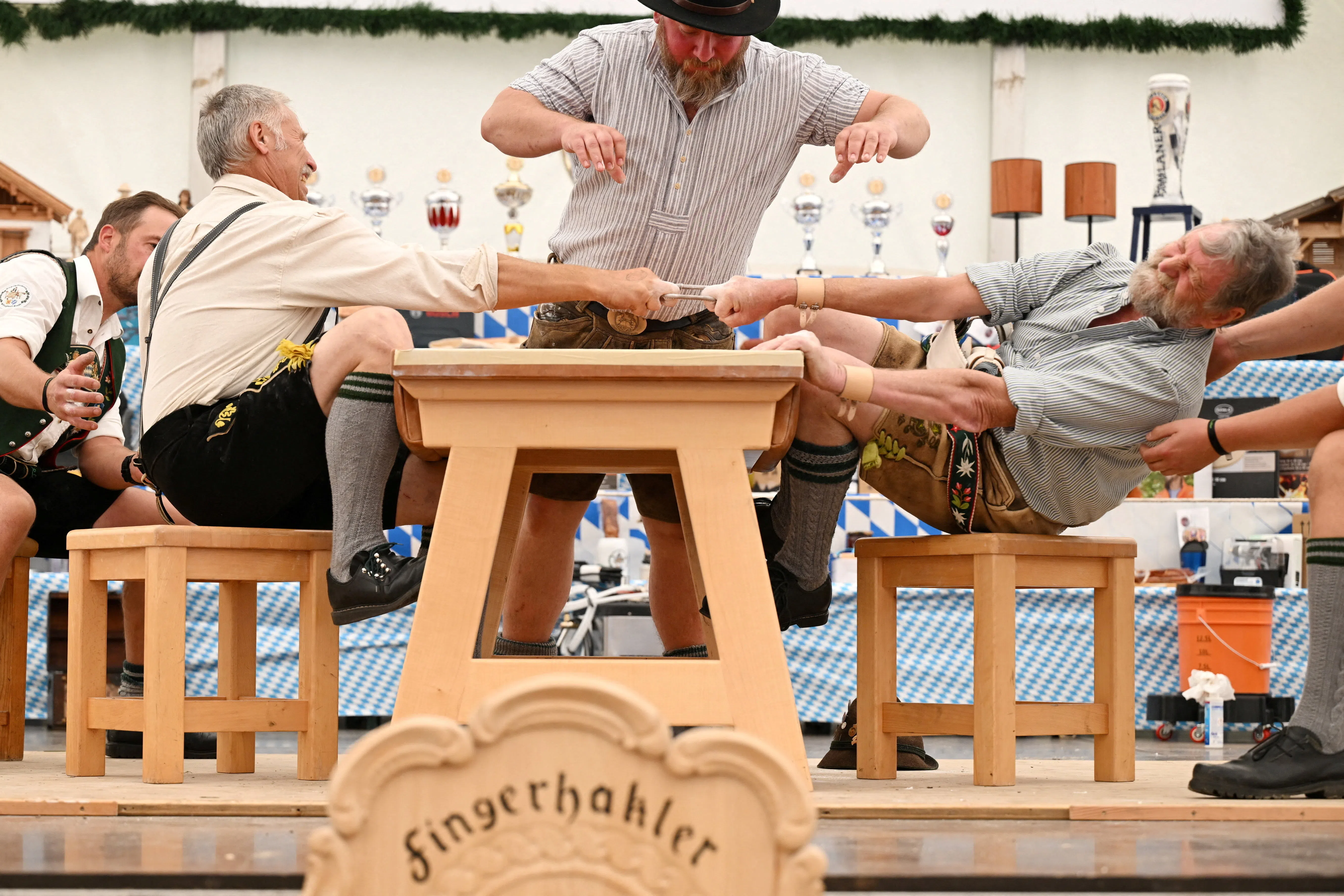 A man tries to pull his opponent over the table during the traditional German finger-pulling (Fingerhakeln) championships in Pflug, Germany, August 23, 2026. REUTERS/Angelika Warmuth         TPX IMAGES OF THE DAY