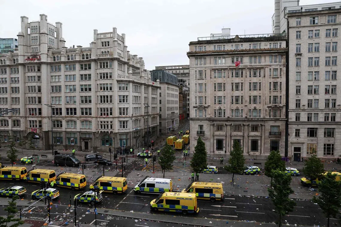 As vans policiais estão estacionadas ao longo do fio quando a ambulância e os veículos da polícia chegam ao local de um incidente em Water Street (traseira), à margem de um desfile de vitória de ônibus aberto para a vitória do título da Premier League do Liverpool, em Liverpool, North-West Inglaterra em 26 de maio de 2025. (Foto de Darren Staples / Afp)