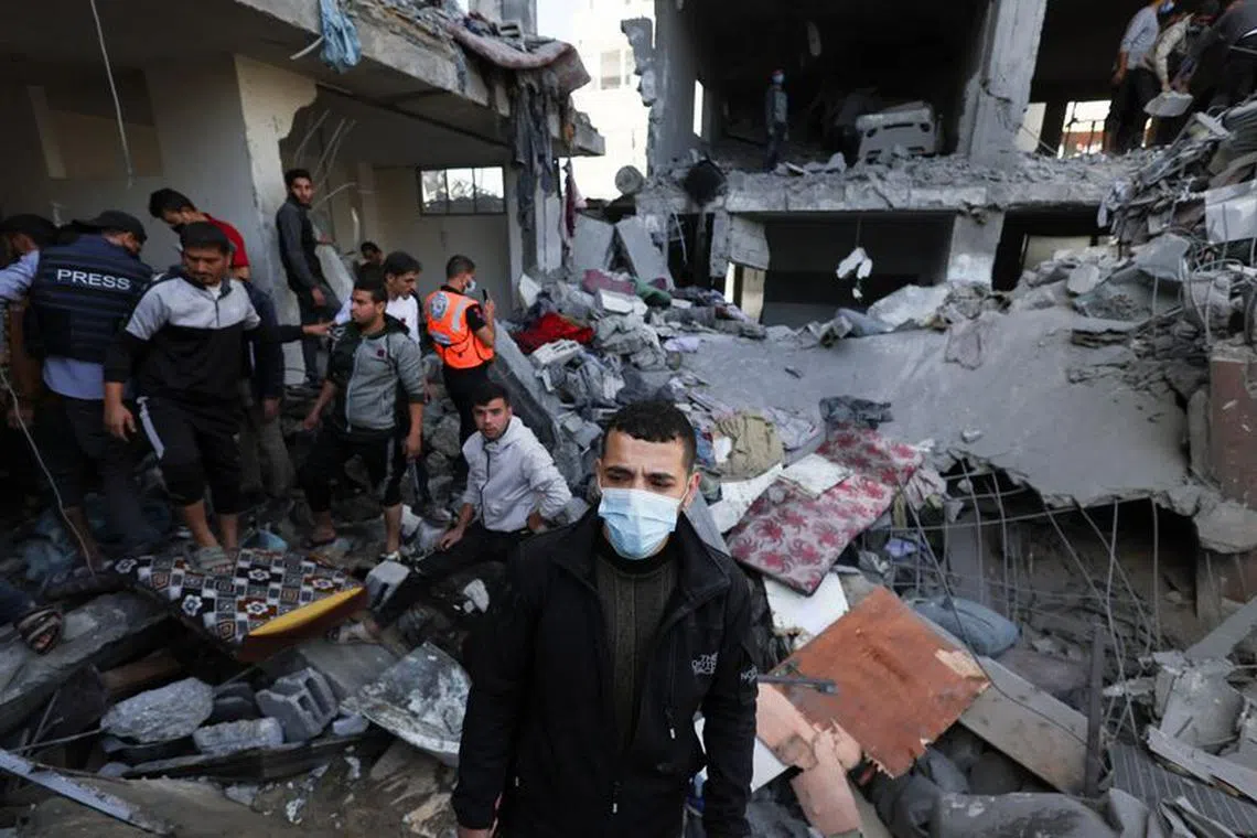 FILE PHOTO: A Palestinian man wears a protective face mask as others search for casualties at the site of an Israeli strike on a house in Rafah, amid the ongoing conflict between Israel and the Palestinian Islamist group Hamas, in the southern Gaza Strip November 23, 2023. REUTERS/Ibraheem Abu Mustafa/File Photo