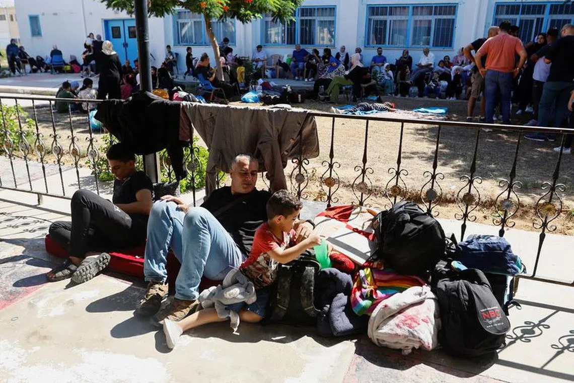 FILE PHOTO: Families of staff of international organisations shelter at a United Nations center after UNRWA said it relocated its central operations centre to the south of Gaza Strip after Israel's call for more than 1 million civilians in northern Gaza to move south within 24 hours, amid the Israeli-Palestinian conflict, in Khan Younis in the southern Gaza Strip October 13, 2023.  REUTERS/Ibraheem Abu Mustafa/File Photo