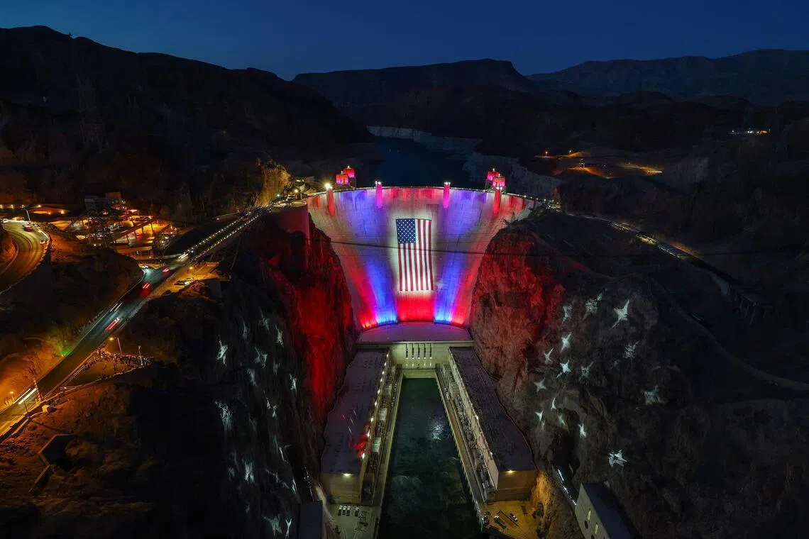 LAKE MEAD NATIONAL RECREATION AREA, NEVADA - JUNE 30: A 300-foot-wide by 150-foot-tall American flag is suspended across the Hoover Dam on June 30, 2026 in the Lake Mead National Recreation Area, Nevada. Beginning on Memorial Day, Nevada, Arizona and the federal Bureau of Reclamation partnered with the Las Vegas Convention and Visitors Authority to hang the 45,000-square-foot, 2,000-pound flag and illuminate it and the surrounding canyon walls with a patriotic lighting display nightly at dusk, pending high winds, through July 4, 2026, to mark the 250th anniversary of the United States Declaration of Independence.   Ethan Miller/Getty Images/AFP (Photo by Ethan Miller / GETTY IMAGES NORTH AMERICA / Getty Images via AFP)