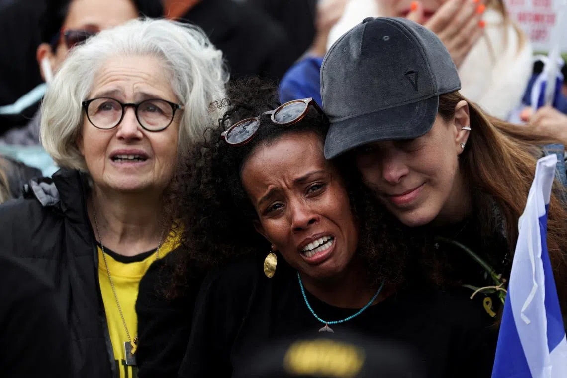 FILE PHOTO: People react as they watch news coverage, on the day of the release of four hostages held in Gaza since the deadly October 7 2023 attack, and two others, who entered Gaza around a decade ago and have been held there since, as part of a ceasefire deal in Gaza between Hamas and Israel, in Tel Aviv, Israel February 22, 2025. REUTERS/Ronen Zvulun/File Photo