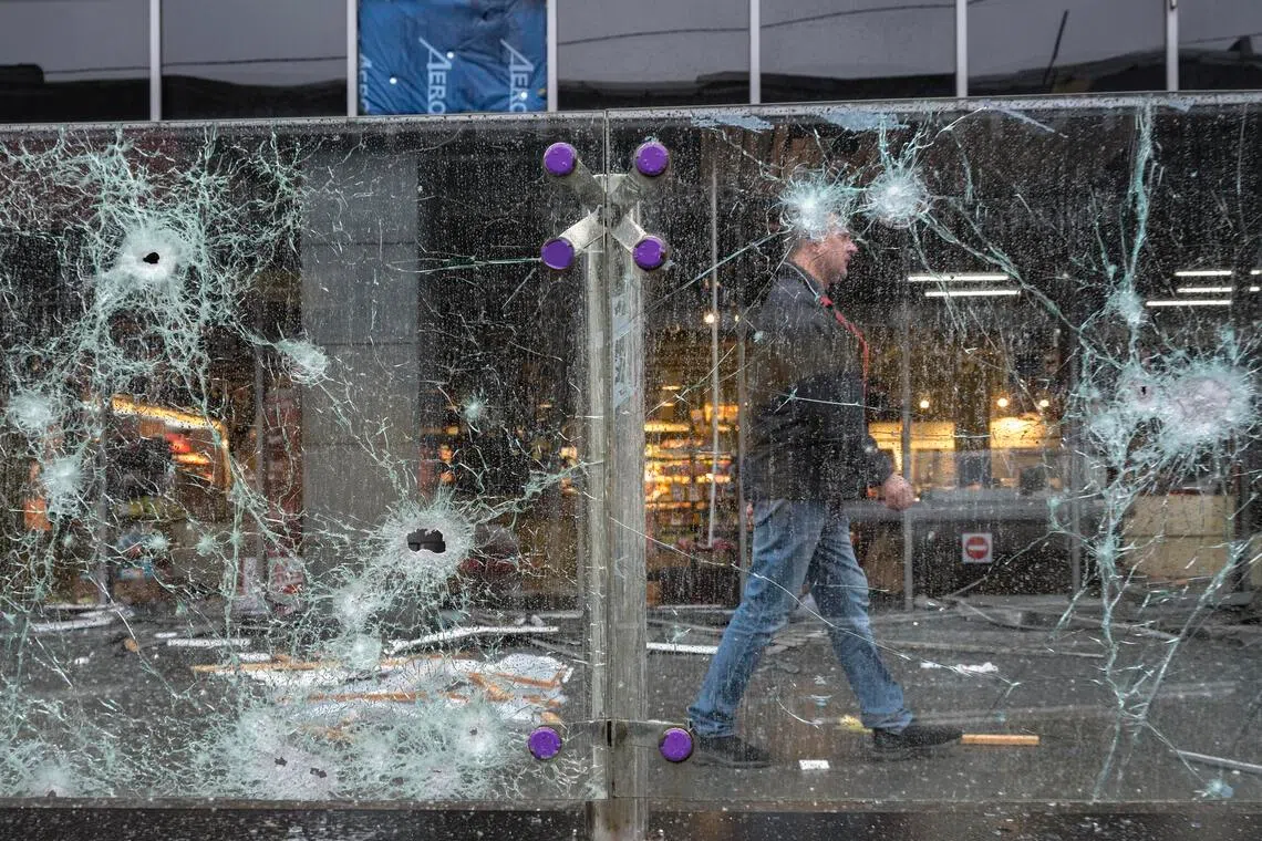 A person walking past the site of a Russian missile strike on a shopping mall in Kyiv, Ukraine, on Oct 19.
