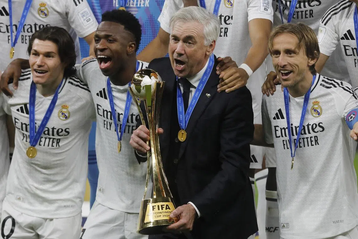 Real Madrid coach Carlo Ancelotti, Fran Garcia, Vinicius Junior and Luka Modric celebrate with the trophy after winning the Intercontinental Cup.