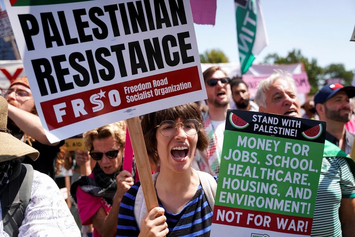 A woman holds a placard, as people take part in the rally \"March on the DNC\" on the first day of the Democratic National Convention (DNC) in Chicago, Illinois, U.S., August 19, 2024.  REUTERS/Seth Herald