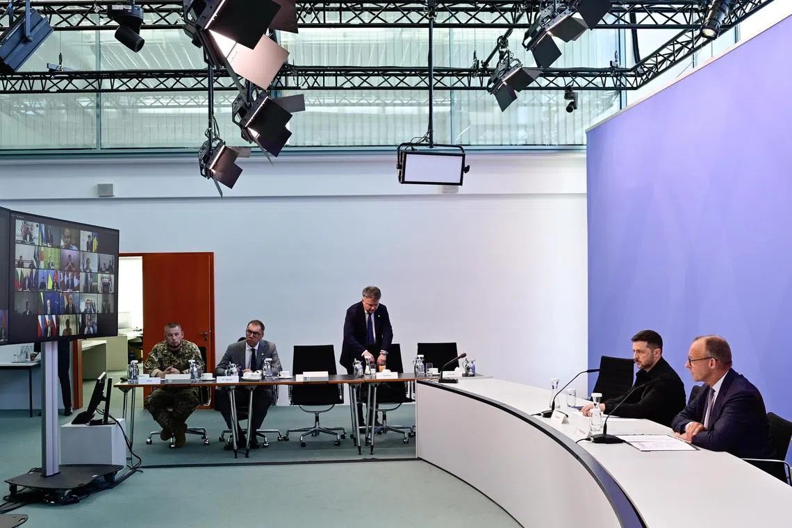 Ukrainian President Volodymyr Zelensky (second from right) and German Chancellor Friedrich Merz (right) taking part in an Aug 13 videoconference call with other European leaders and the US (on screen).