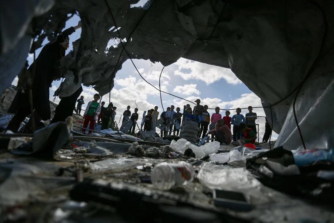 Palestinian children gathering at the site of an Israeli strike, on a tent housing displaced people, in Khan Younis, in the southern Gaza Strip, on March 19, 2025.