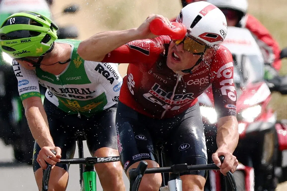 Lotto Intermarche’s Baptiste Veistroffer dousing himself with water while cycling, during stage seven of the Tour de France on July 10.