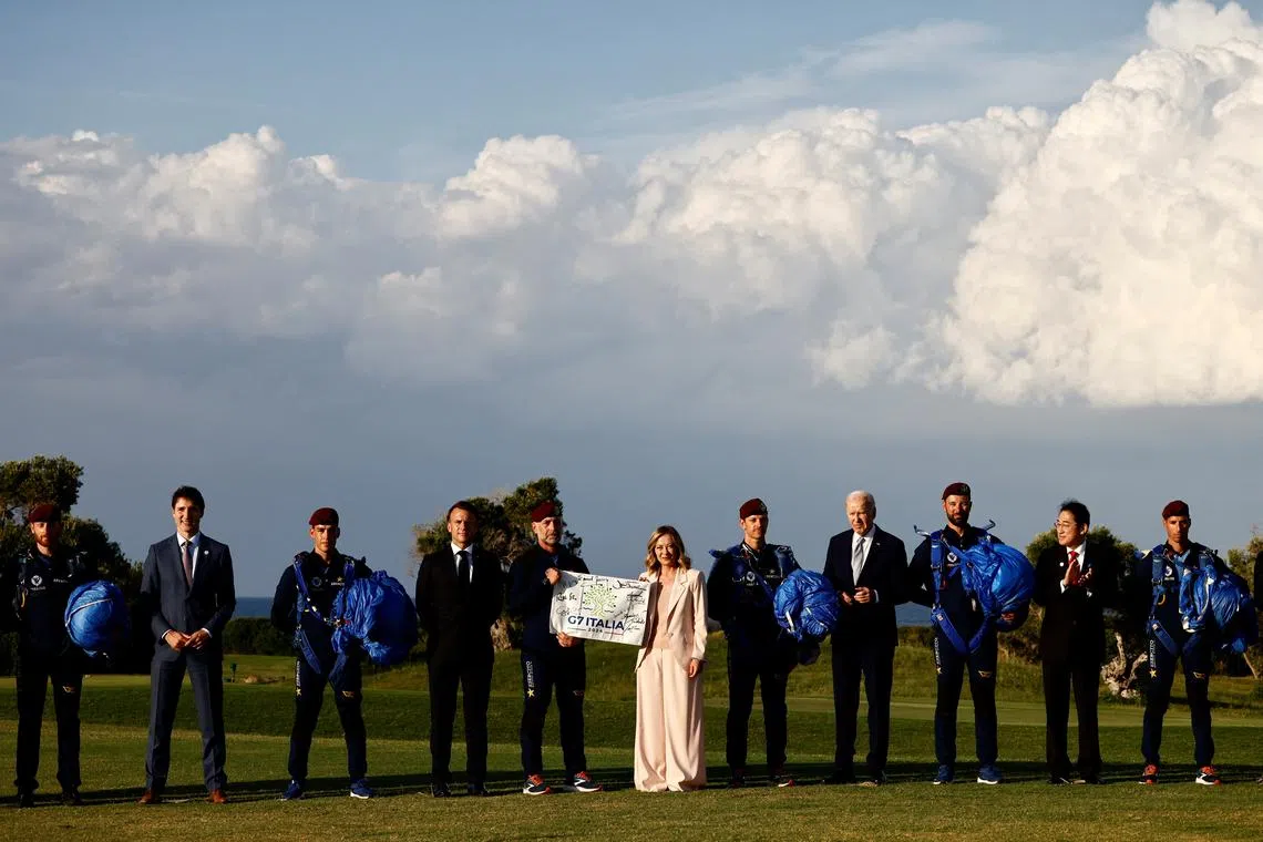 Italy's Prime Minister Giorgia Meloni holds a G7 Italia banner next to U.S. President Joe Biden, Canada's Prime Minister Justin Trudeau, France's President Emmanuel Macron and Japan's Prime Minister Fumio Kishida on the first day of the G7 summit, in Savelletri, Italy, June 13, 2024. REUTERS/Yara Nardi