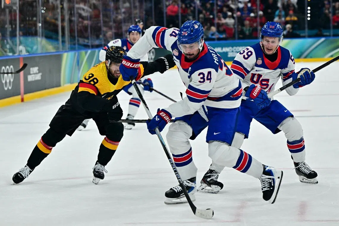 Milano Cortina 2026 Olympics - Ice Hockey - Men's Preliminary Round - Group C - United States vs Germany - Milano Santagiulia Ice Hockey Arena, Milan, Italy - February 15, 2026. Auston Matthews of United States and Jake Guentzel of United States in action with Fabio Wagner of Germany REUTERS/Marton Monus