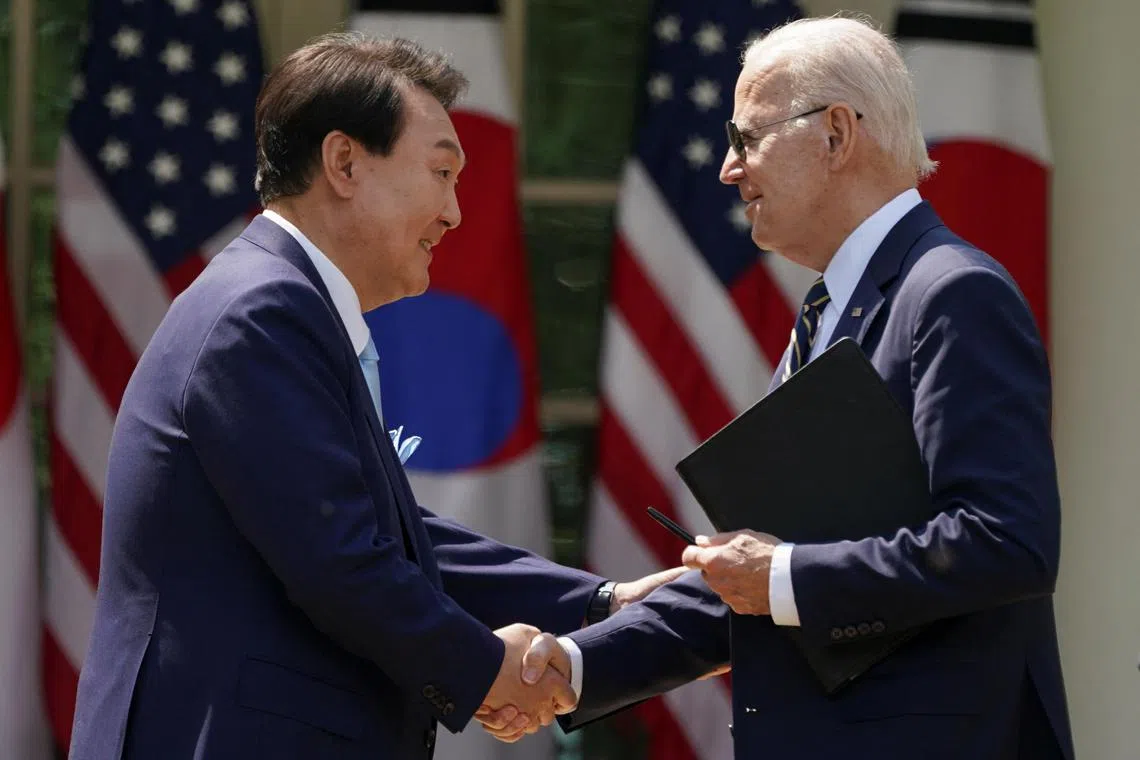 South Korean President Yoon Suk Yeol (left) and US President Joe Biden shake hands at the end of a joint White House news conference.