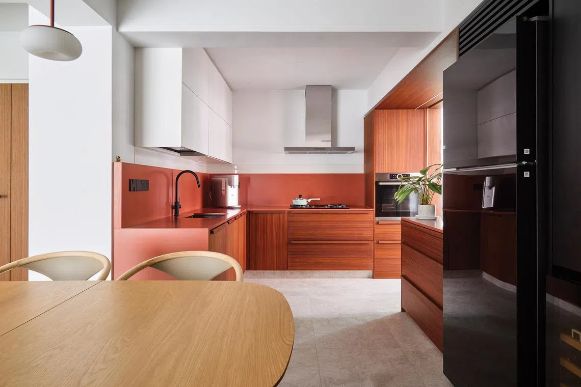Removing the wall separating the kitchen and the dining area creates an open-concept layout for this BTO flat.