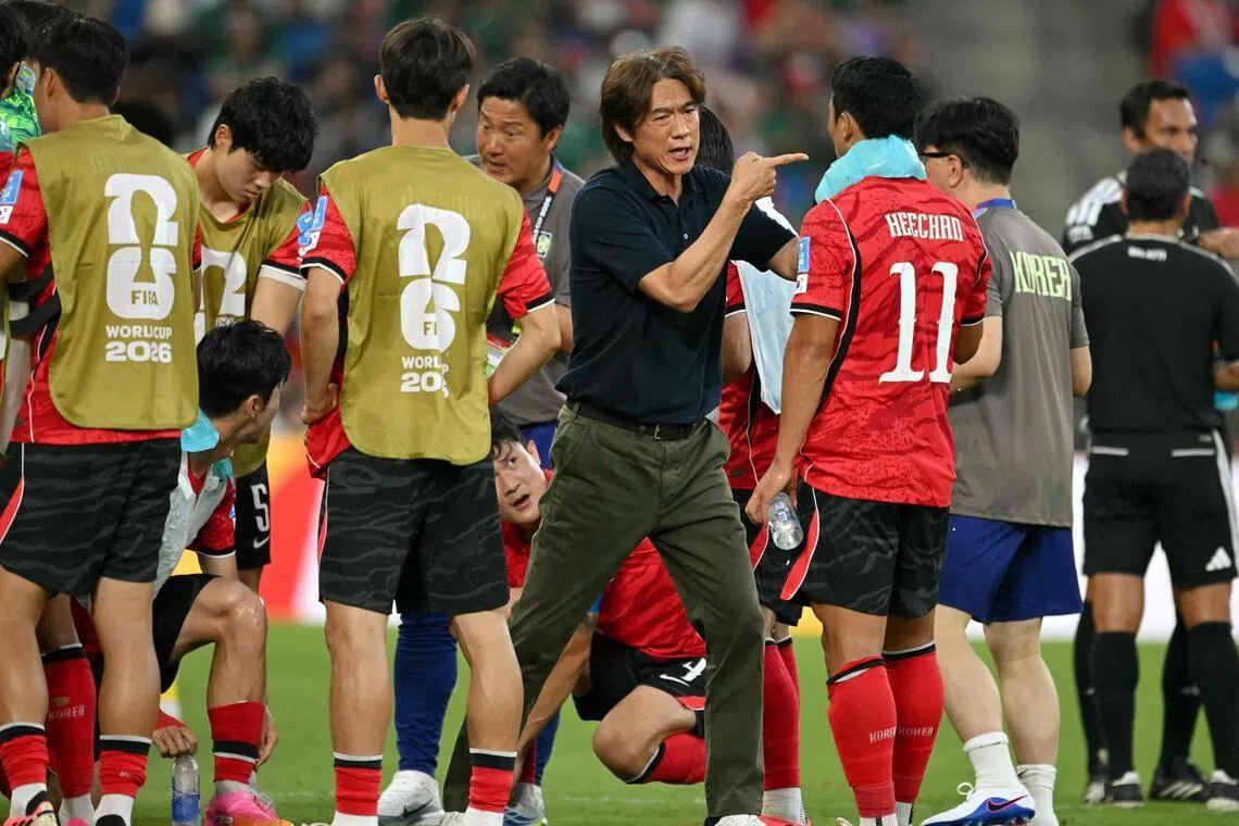 South Korea's head coach Hong Myung-bo talks to his players  during a hydration break of the 2026 World Cup Group A football match between South Africa and South Korea at the Monterrey Stadium in Guadalupe, Mexico, on June 24, 2026.  (Photo by Yuri CORTEZ / AFP)