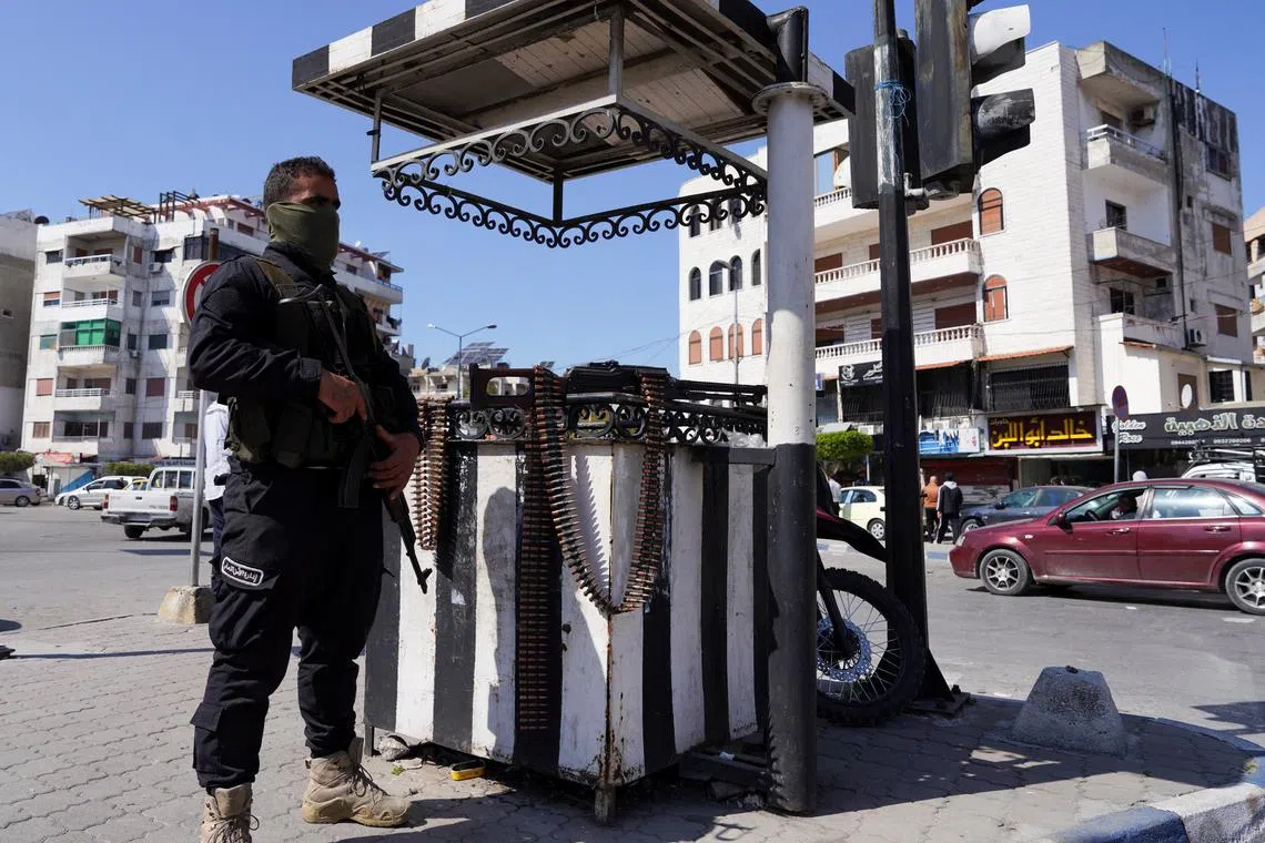 FILE PHOTO: A member of the Syrian security forces stands guard along a street, after hundreds were killed in some of the deadliest violence in 13 years of civil war, pitting loyalists of deposed President Bashar al-Assad against the country's new Islamist rulers, in Latakia, Syria March 10, 2025. REUTERS/Karam al-Masri/File Photo