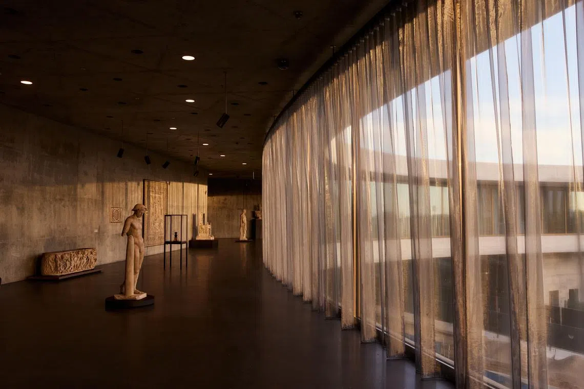 Works by one of the museum's walls of windows, shielded from light damage by sheer curtains.