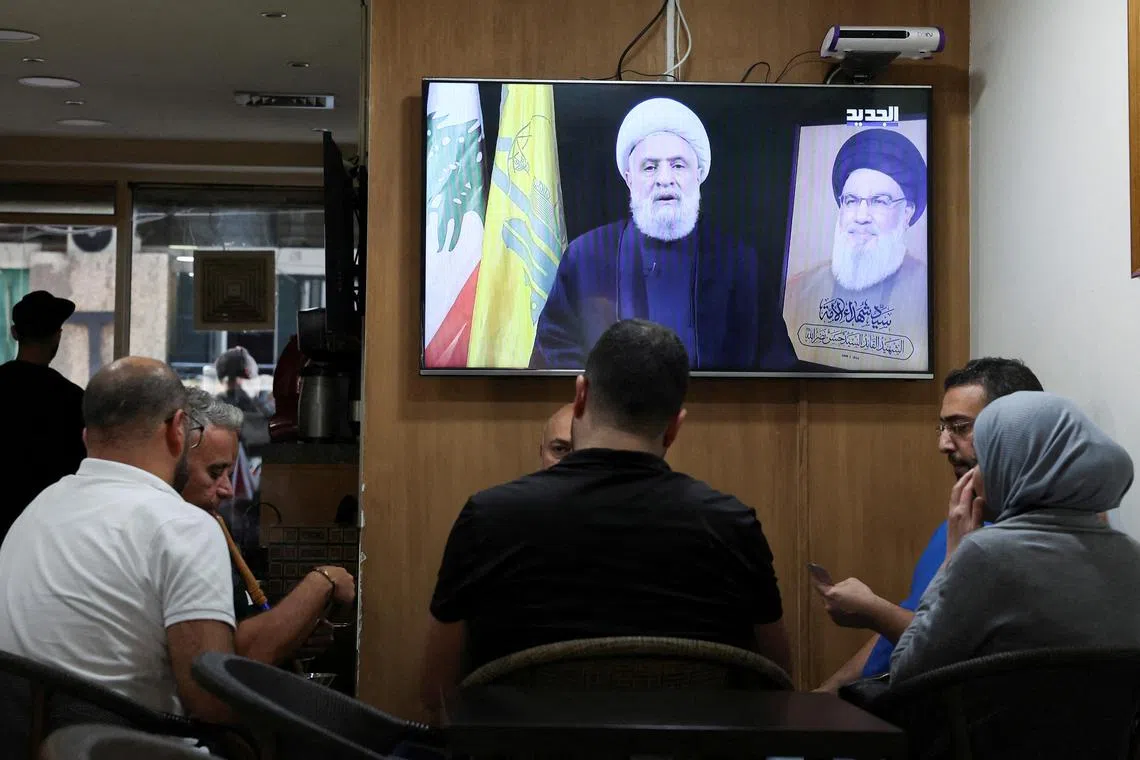 People listening an address by Hezbollah leader Sheikh Naim Qassem at a cafe in Beirut, Lebanon.