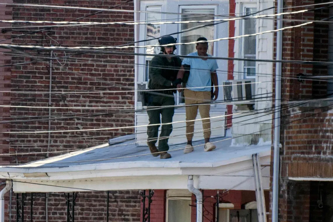 Armed Swat officers were seen using a ladder to climb onto the roof of the porch to help people inside escape through a window.