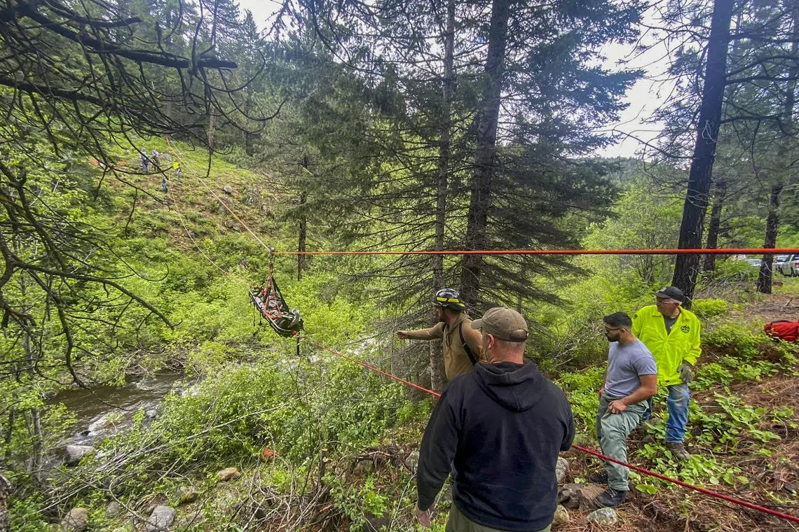Members of the Baker County Search and Rescue Ropes Team pulling Mr Brandon Garrett, in a rescue basket, across a ravine in eastern Oregon.