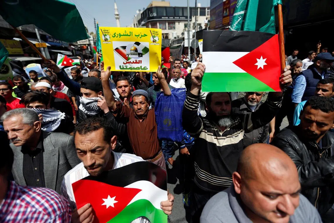 Supporters of the Muslim Brotherhood hold Jordanian flags and chant slogans during a pro-Palestinian demonstration after Friday prayers in Amman, Jordan, April 13, 2018. The placard reads: \"Jerusalem our capital\". REUTERS/Muhammad Hamed